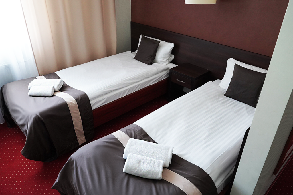 widok na pokój czteroosobowy w Hotelu Maraton, na którym widać dwa jednoosobowe łóżka