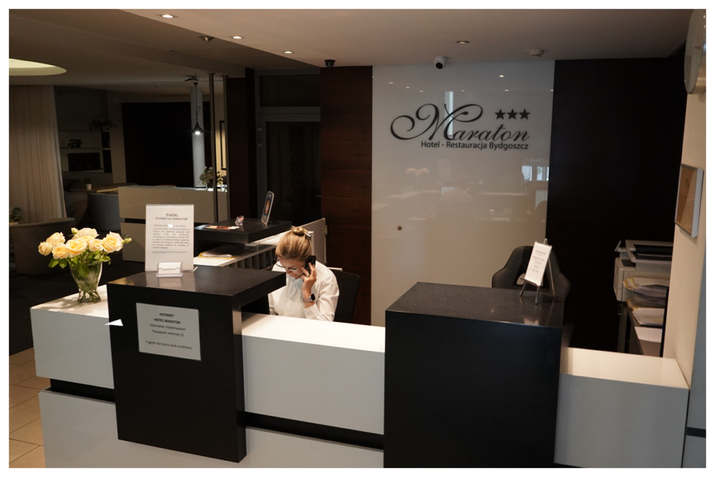 recepcja bydgoskiego Hotelu Maraton z siedzącą za kontuarem recepcjonistką