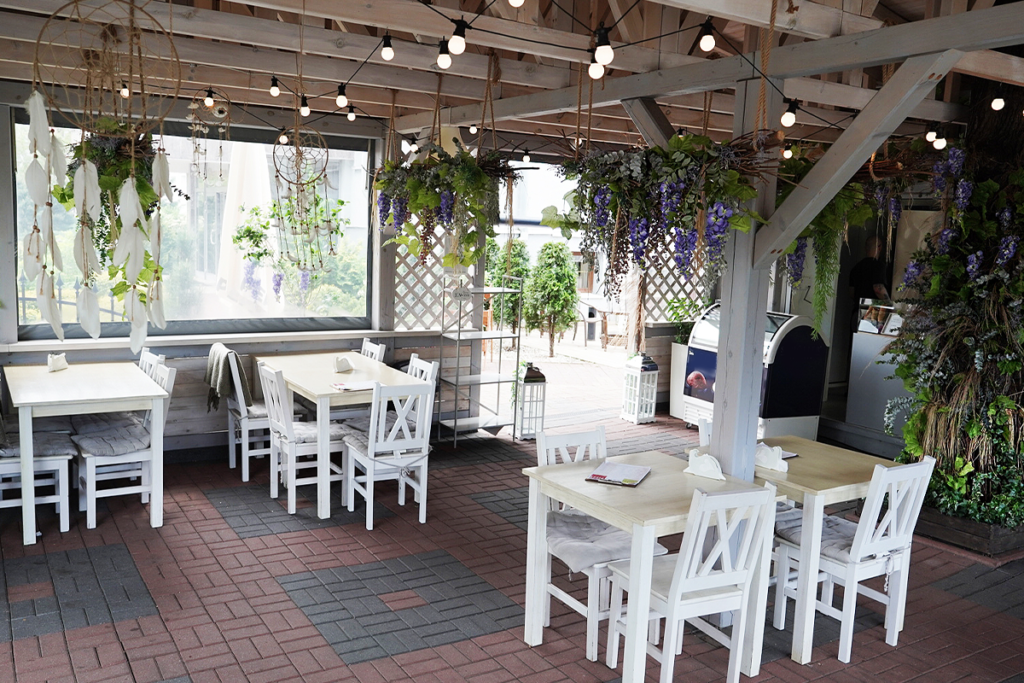 wnętrze bydgoskiego bistro Maraton, z drewnianymi krzesłami i stolikami w kolorze białym